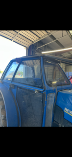 Blue agricultural tractor cab undergoing fabrication work
