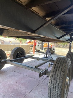 Trailer axle aligned beneath a fabricated frame